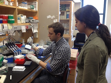 Trainee Peter Wagner gives undergraduate intern Lucy Suarez an introduction to Dr. Quan Lu's lab.