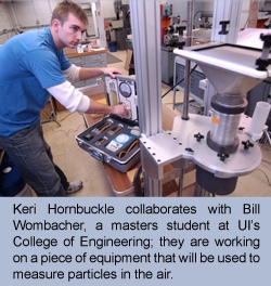 Keri Hornbuckle collaborates with BillWombacher, a masters student at UI's College of Engineering; they are working on a piece of equipment that will be used to measuer partiles in the air.