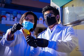 Two scientists in the lab examining a yellow sample