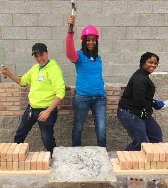 : Flint ECWTP graduates Emily Williams, Shanell Tiggs, and Lanae Bell (left to right) in action at the WIST Women Build event.