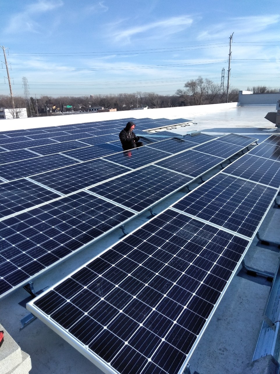 Trainee pictured on the job stie with solar panels. (Photo courtesy of Kentina Kellum, OAI, Inc.).